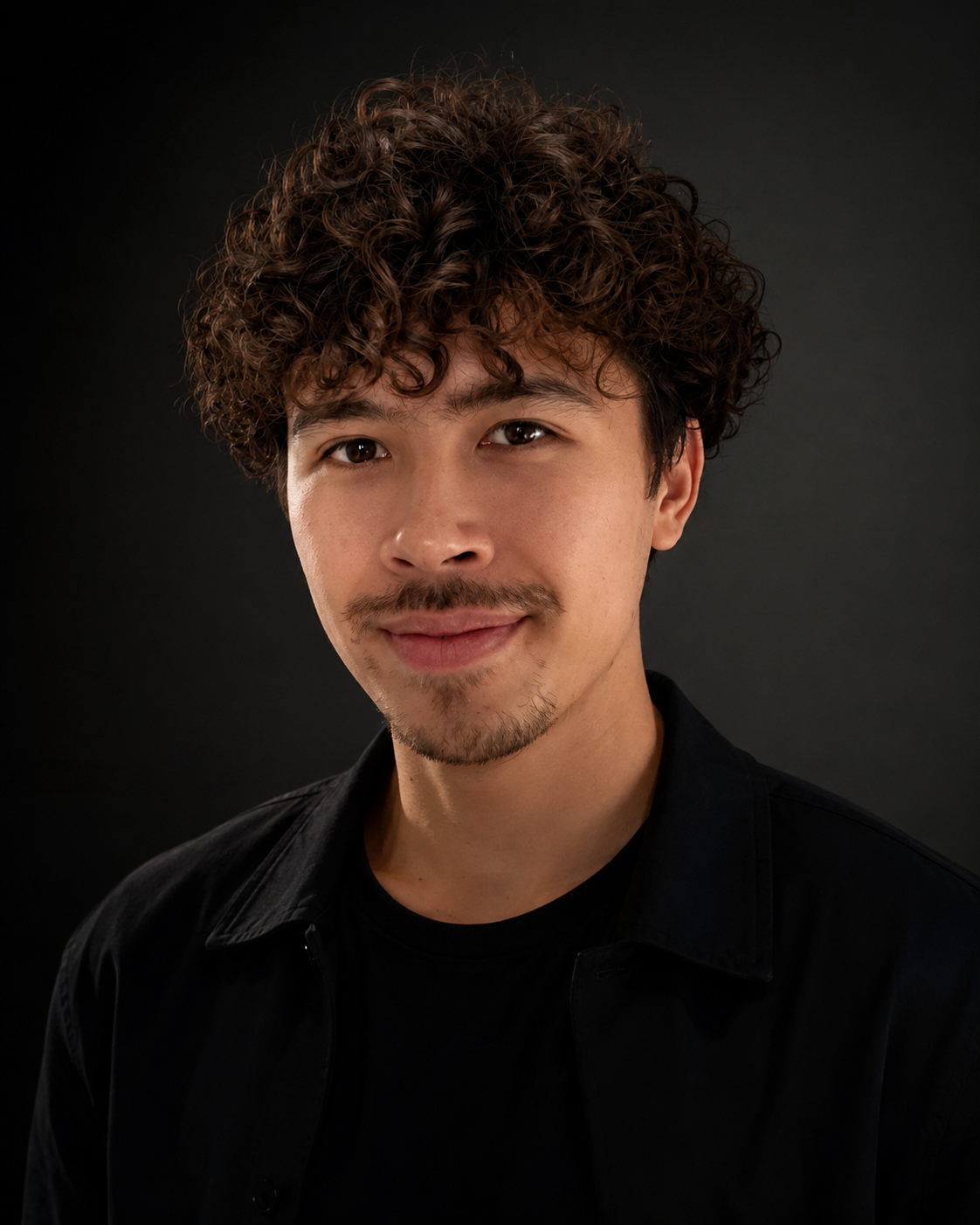 Portrait of Jamie Graham holding an electric guitar in a warmly lit studio